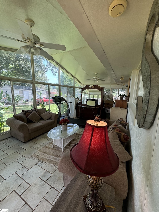 living room with plenty of natural light, ceiling fan, and lofted ceiling