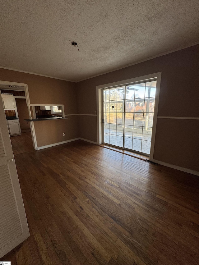 unfurnished living room featuring dark wood-type flooring and a textured ceiling