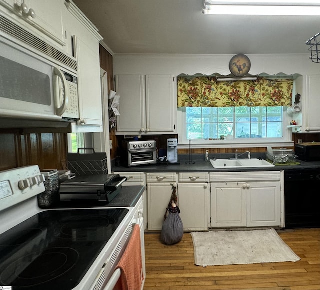 kitchen featuring white cabinetry, white appliances, sink, and light hardwood / wood-style flooring