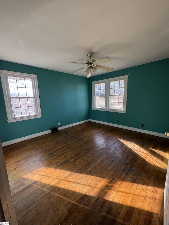 spare room with ceiling fan and dark hardwood / wood-style flooring