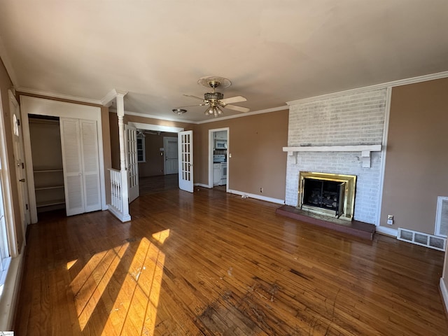 unfurnished living room with ceiling fan, french doors, dark hardwood / wood-style flooring, a fireplace, and ornamental molding