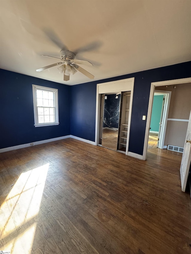 empty room featuring ceiling fan and dark wood-type flooring