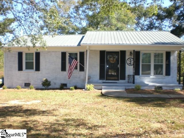 single story home with covered porch and a front yard