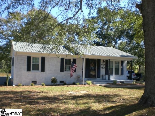 single story home featuring a porch and a front yard