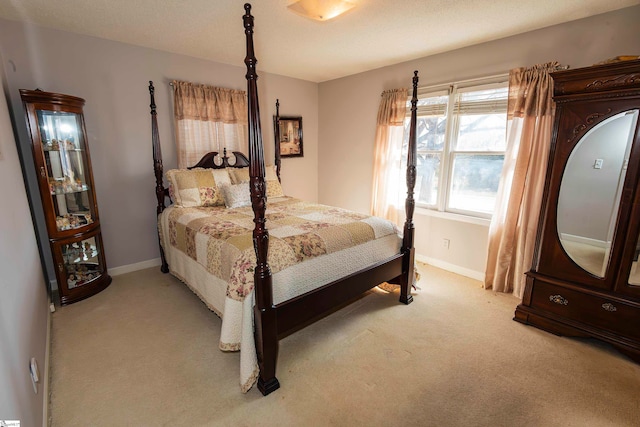 bedroom featuring a textured ceiling and light colored carpet