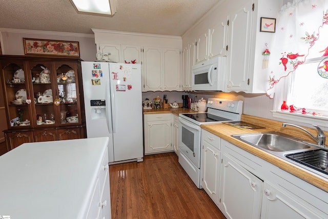 kitchen featuring dark hardwood / wood-style floors, ornamental molding, white cabinetry, a textured ceiling, and white appliances