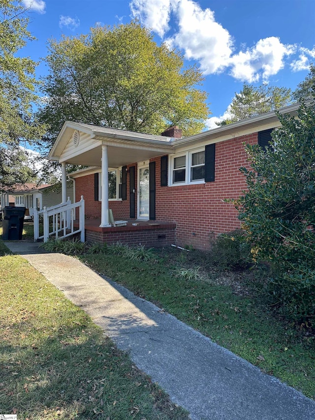 view of front of property featuring a front yard and covered porch