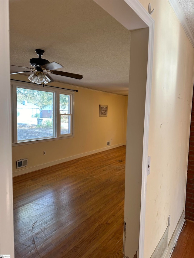 unfurnished room featuring dark wood-type flooring, a textured ceiling, and ceiling fan