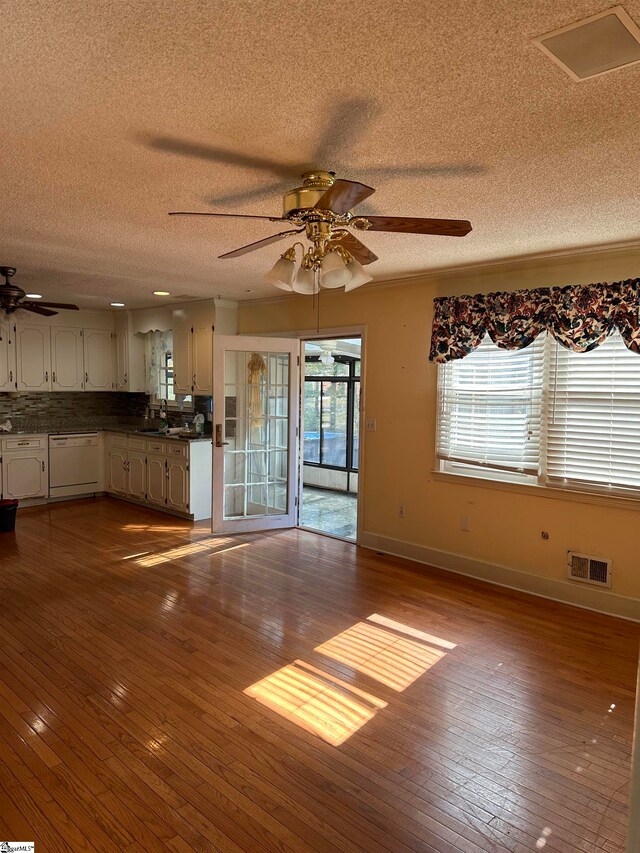 unfurnished living room featuring hardwood / wood-style floors, a textured ceiling, sink, and ceiling fan