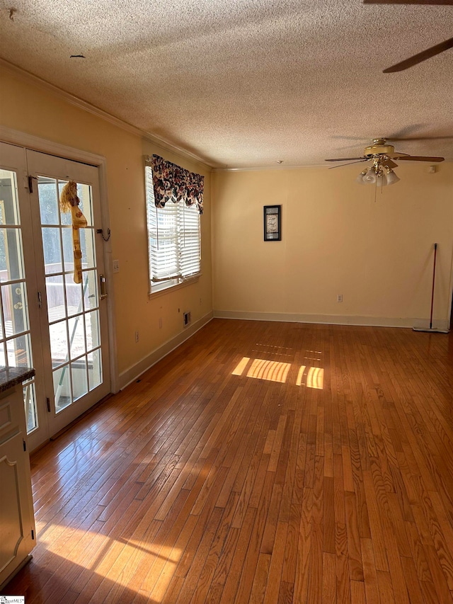 empty room featuring hardwood / wood-style flooring, ceiling fan, and a textured ceiling