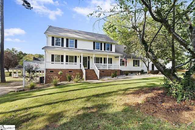 colonial inspired home with a porch, a front yard, and crawl space