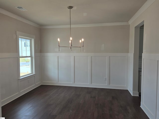 unfurnished dining area featuring dark hardwood / wood-style floors, ornamental molding, and a notable chandelier