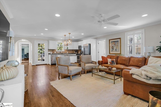 living room featuring ornamental molding, hardwood / wood-style flooring, and ceiling fan