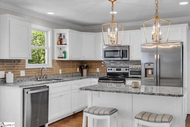 kitchen featuring white cabinetry, appliances with stainless steel finishes, and pendant lighting