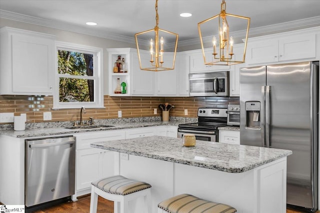 kitchen with appliances with stainless steel finishes, sink, decorative light fixtures, and white cabinets