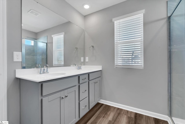 bathroom with vanity, a healthy amount of sunlight, wood-type flooring, and a shower with door