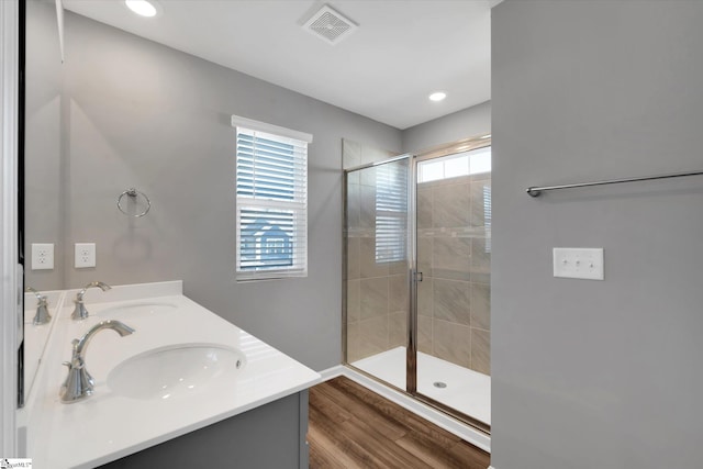 bathroom with vanity, wood-type flooring, plenty of natural light, and an enclosed shower