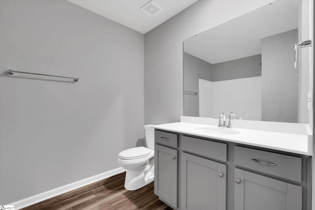 bathroom with vanity, wood-type flooring, and toilet