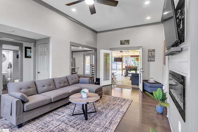 living room featuring ceiling fan, ornamental molding, and dark hardwood / wood-style flooring