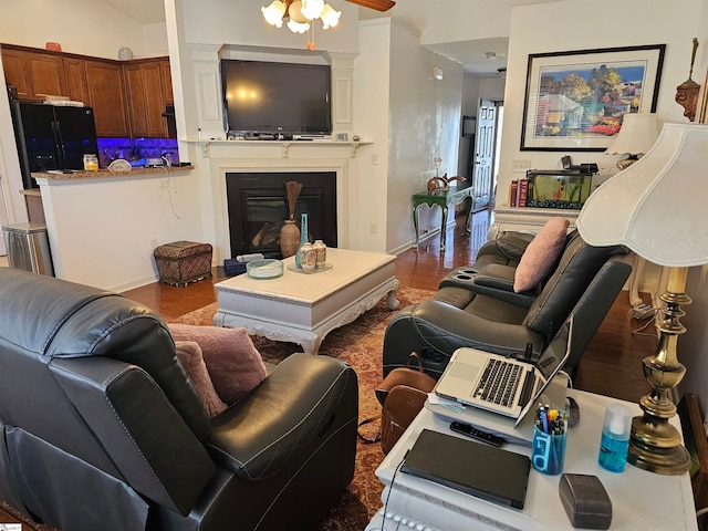 living room with wood-type flooring, vaulted ceiling, and ceiling fan