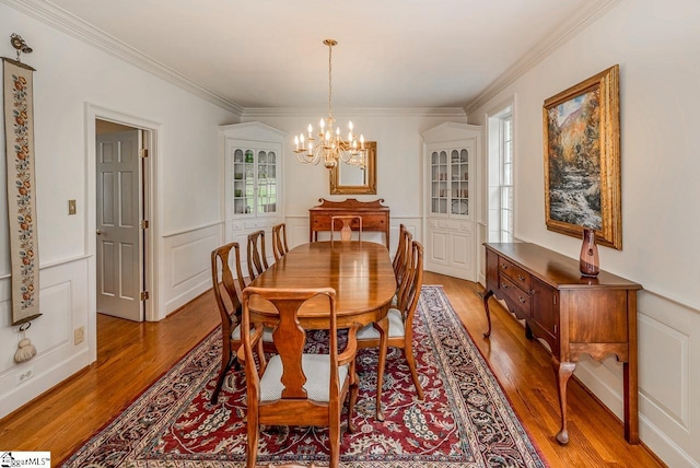 dining area featuring ornamental molding, hardwood / wood-style floors, a chandelier, and a wealth of natural light