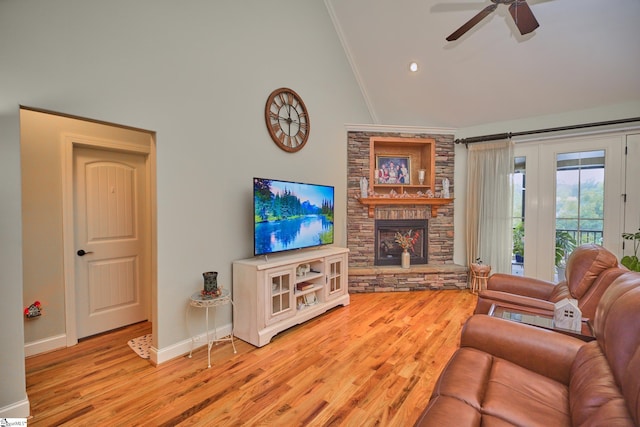 living room featuring lofted ceiling, ceiling fan, a fireplace, light hardwood / wood-style floors, and crown molding