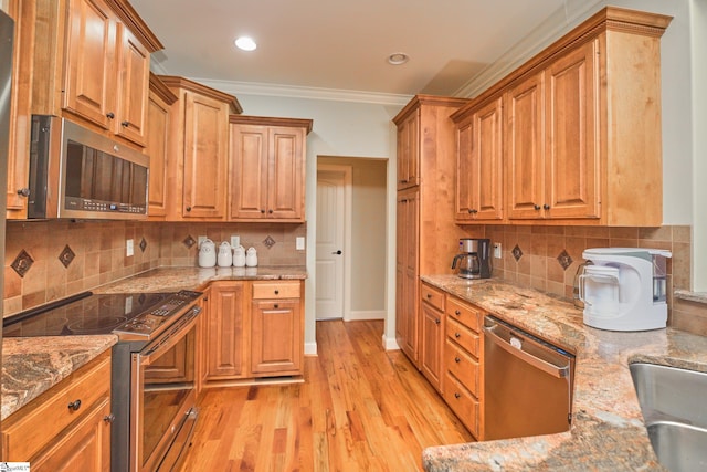 kitchen featuring decorative backsplash, appliances with stainless steel finishes, light wood-type flooring, crown molding, and light stone counters