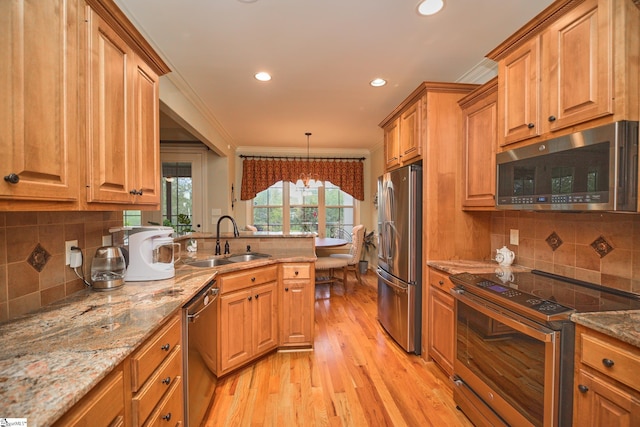 kitchen with appliances with stainless steel finishes, sink, light wood-type flooring, crown molding, and a notable chandelier