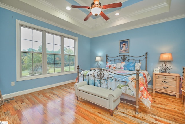 bedroom featuring ceiling fan, crown molding, light hardwood / wood-style flooring, and a raised ceiling