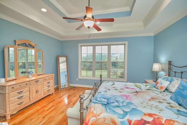 bedroom featuring crown molding, light hardwood / wood-style flooring, a raised ceiling, and ceiling fan