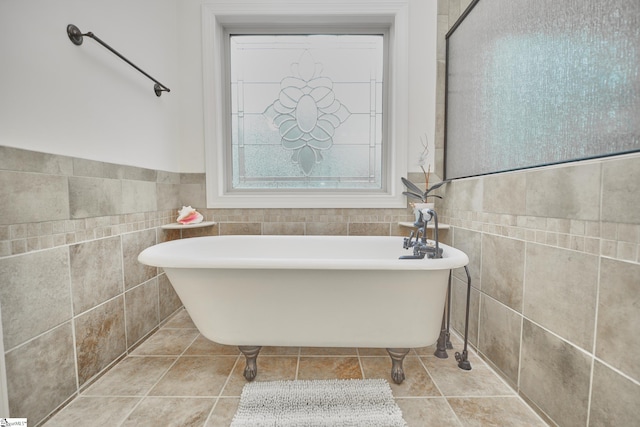 bathroom featuring tile walls, a tub to relax in, and tile patterned floors