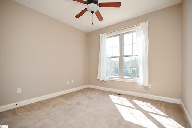 spare room with light colored carpet and ceiling fan