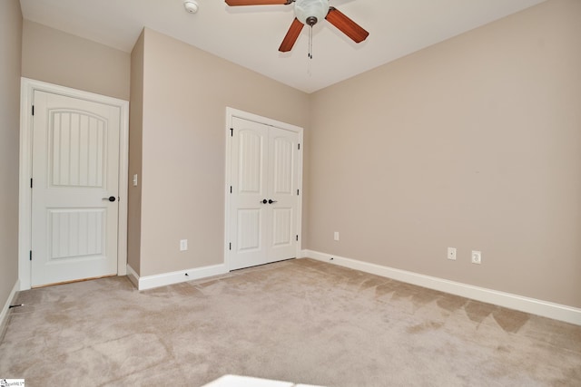 unfurnished bedroom featuring light colored carpet and ceiling fan