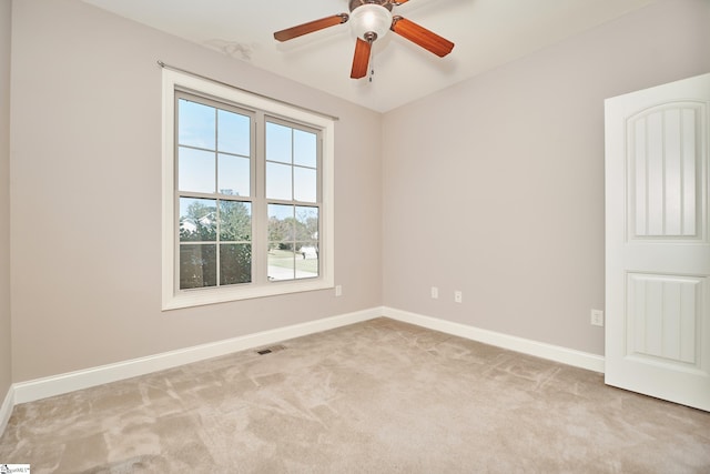 carpeted spare room featuring ceiling fan