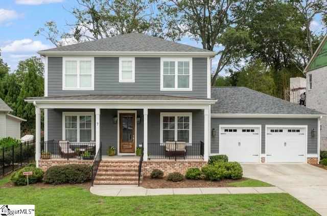 view of front property featuring a front lawn, covered porch, and a garage