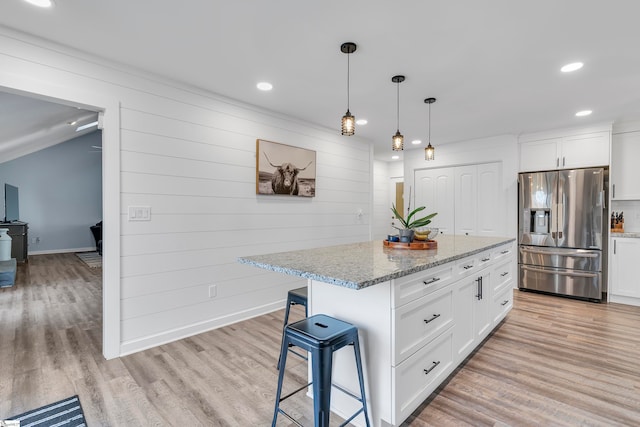 kitchen featuring a center island, white cabinets, and stainless steel refrigerator with ice dispenser