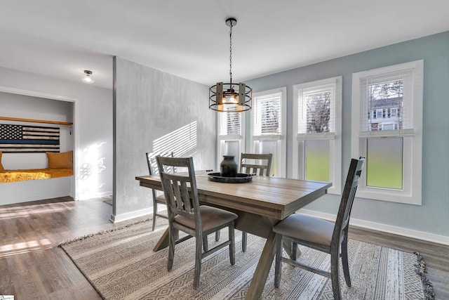 dining area with hardwood / wood-style floors and a notable chandelier