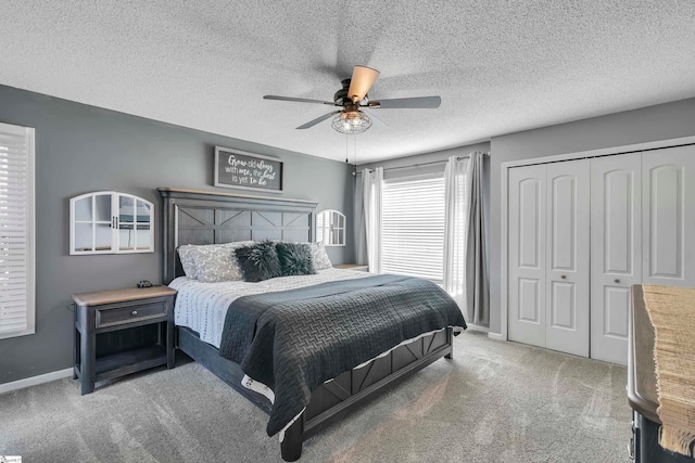 bedroom with a textured ceiling, carpet flooring, a closet, and ceiling fan