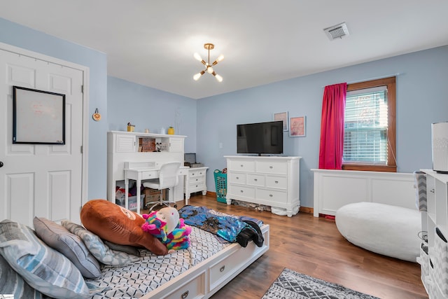 bedroom featuring dark hardwood / wood-style floors and an inviting chandelier