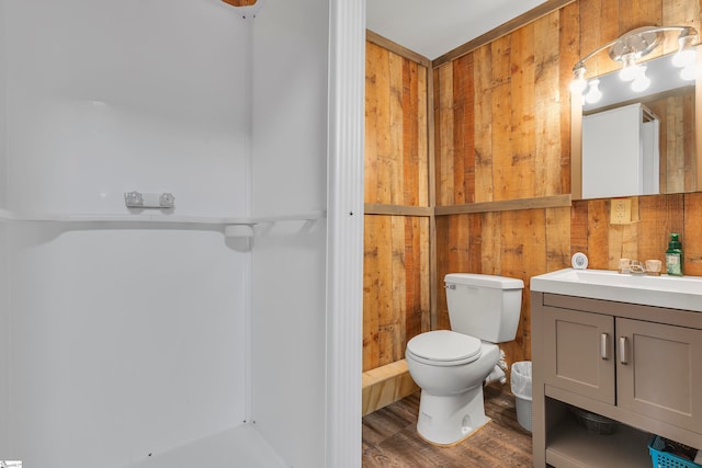 bathroom with vanity, toilet, wood walls, and wood-type flooring