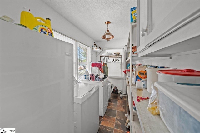 laundry room featuring cabinets, independent washer and dryer, and a textured ceiling