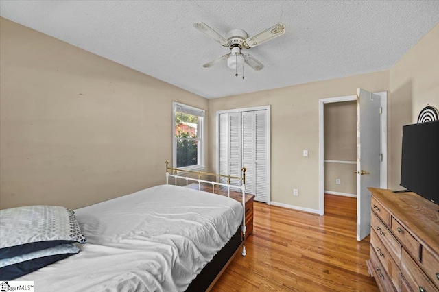 bedroom with a closet, ceiling fan, a textured ceiling, and light hardwood / wood-style flooring