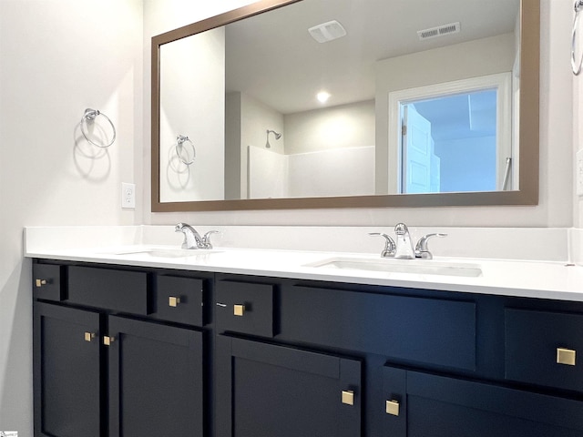 bathroom featuring visible vents, a sink, and double vanity