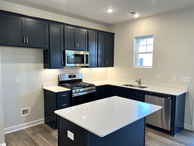 kitchen with a sink, light wood-style floors, stainless steel appliances, and visible vents