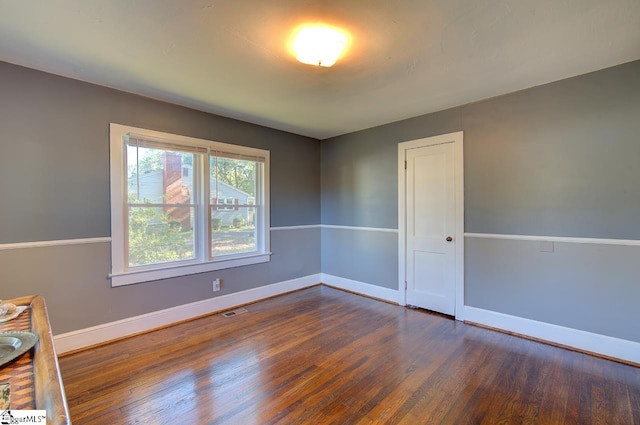 empty room with dark hardwood / wood-style floors