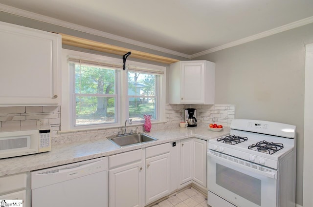 kitchen with white appliances, decorative backsplash, sink, and white cabinets