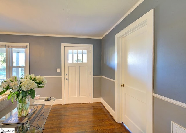 foyer entrance featuring dark wood-type flooring, crown molding, and plenty of natural light