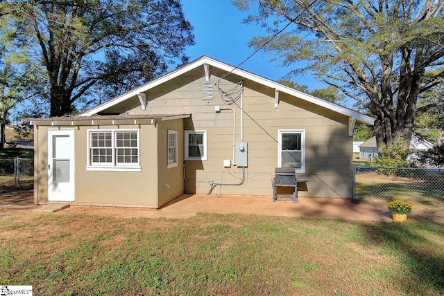 rear view of house featuring a lawn