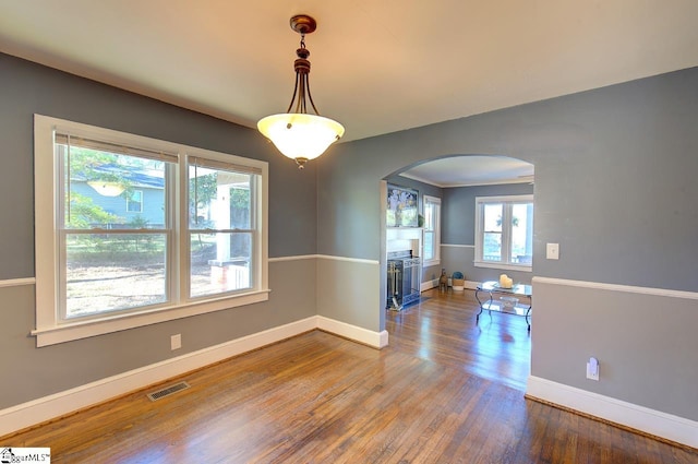 empty room with ornamental molding and hardwood / wood-style floors