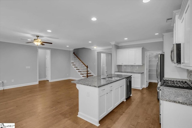 kitchen featuring white cabinets, a center island with sink, appliances with stainless steel finishes, light hardwood / wood-style flooring, and stone countertops